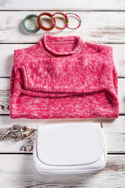 Білий гаманець і рожевий светр
. - Фото, зображення