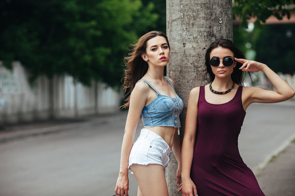 Two beautiful young girls posing in the city - Photo, Image