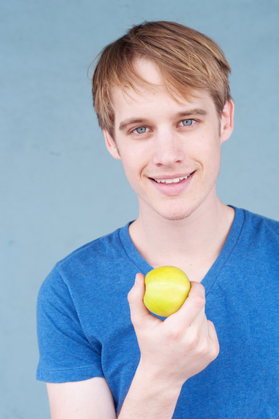 Portrait of a young man with an apple - Valokuva, kuva