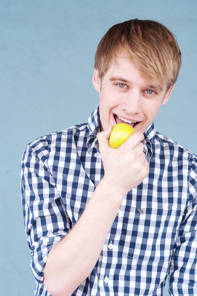 Portrait of a young man with an apple - Foto, imagen