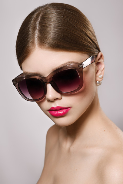 Portrait of beautiful girl in sunglasses with red lips - Фото, зображення