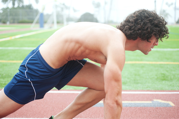 Athletic male runner in ready position - Zdjęcie, obraz