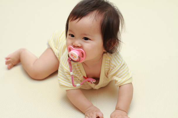 Japanse babymeisje zuigen op een fopspeen (0 jaar oud) - Foto, afbeelding