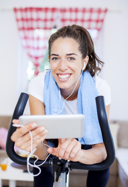 woman training on exercise bike using tablet - Foto, immagini