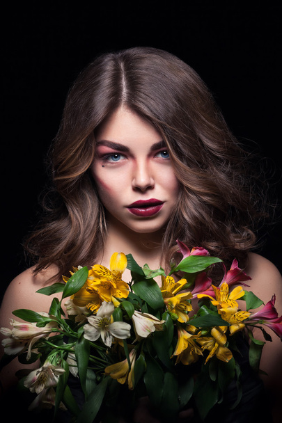 young blonde girl keeps flowers on black background - Foto, Imagem