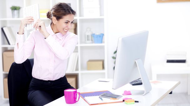 angry businesswoman about to break computer - Zdjęcie, obraz
