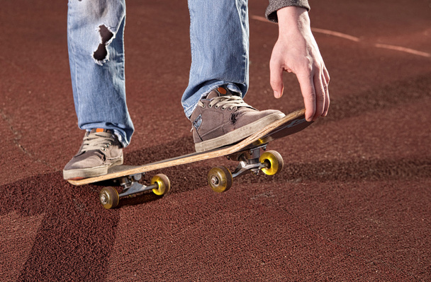 Teenager doing exercises on a skateboard - Fotoğraf, Görsel