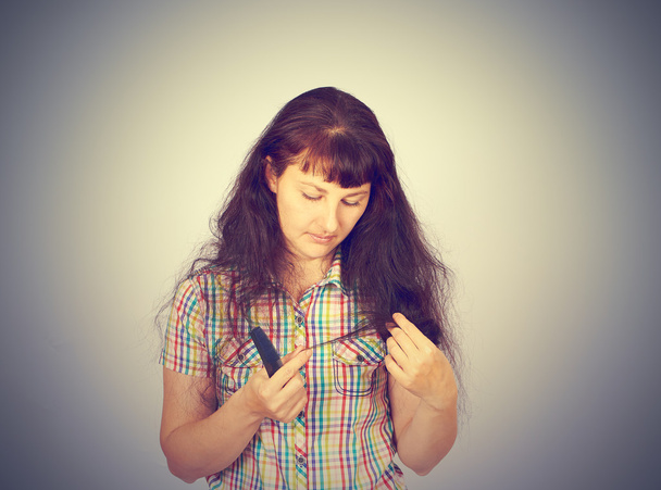 mujer joven mira su cabello problemático
 - Foto, imagen
