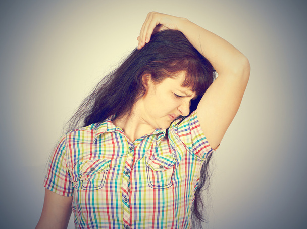 young woman, smelling, sniffing her armpit - Photo, Image