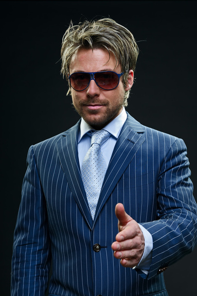 stylischer Geschäftsmann mit kurzen blonden Haaren im blau gestreiften Anzug und hellblauer Krawatte. - Foto, Bild