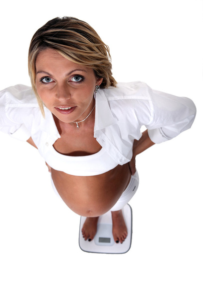 Pregnant woman on scales - 写真・画像