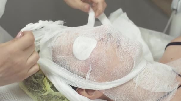 Kozmetikus tesz távoli cheesecloth ki nő arcát a szépségszalon. Vattát - Felvétel, videó