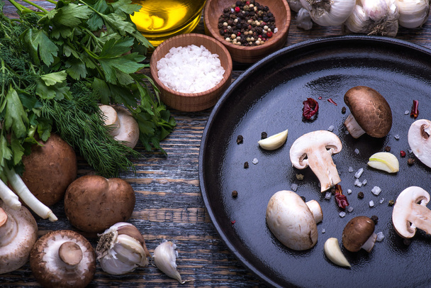 Mushrooms, parsley, dill, onion, olive oil, spices - ingredients for the preparation of mushroom dishes on the wooden background - Photo, image