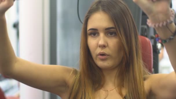 Beautiful young woman doing exercises to strengthen the shoulder simulator - Video, Çekim