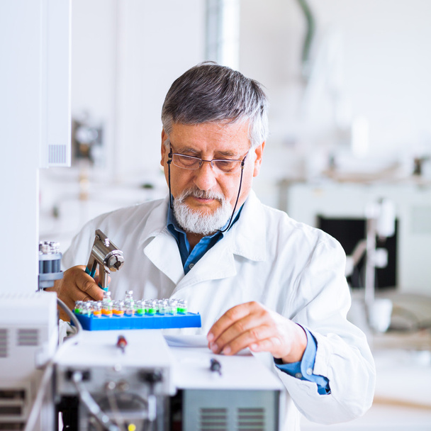 Senior male researcher carrying out scientific research in a lab - Foto, afbeelding