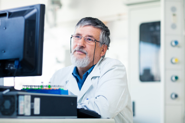 Senior researcher using a computer in the lab - 写真・画像