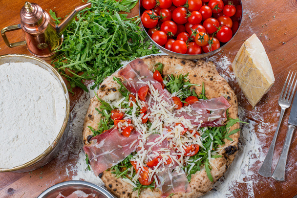 Primer plano de jamón ahumado italiano y pizza de rúcula
 - Foto, imagen