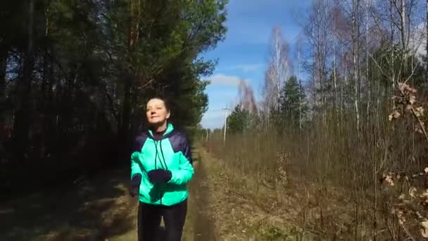 Starsza kobieta biegnie szlakiem lasu. - Materiał filmowy, wideo