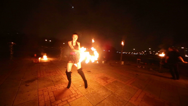 Mädchen tanzt mit brennenden Fackeln, Kerl macht Feuerbälle - Filmmaterial, Video