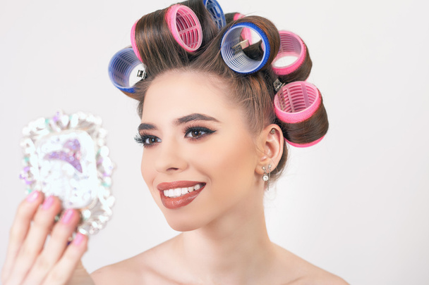Young girl doing makeup and hairstyle using curlers - Foto, Imagem