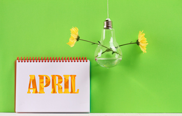 Modern bulb vase with flowers and April poster. Springtime background - 写真・画像
