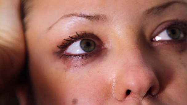 Közeli kép a lány könnyes szemmel. Piszok a tinta az arcon. - Felvétel, videó