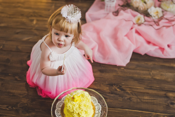 The girl tastes the cake on their first birthday 5404. - Foto, immagini