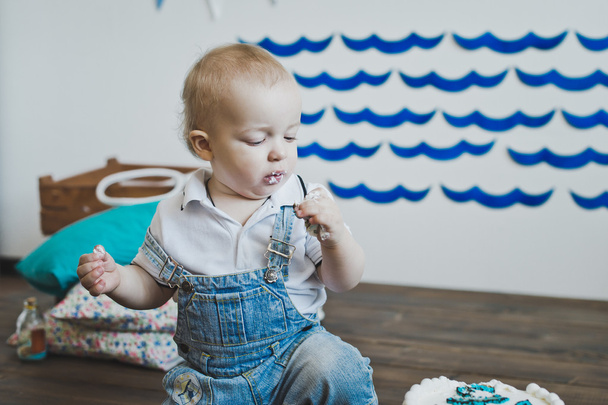 The baby eats cake with his hands 5566. - Valokuva, kuva