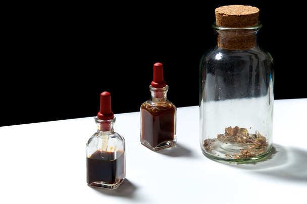 três garrafas de vidro com extratos de ervas
 - Foto, Imagem
