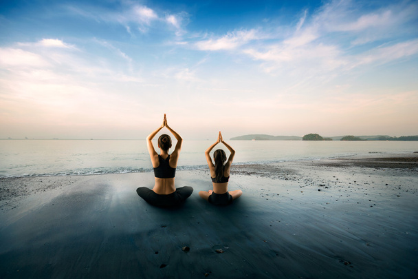 Mère et fille faisant du yoga à la plage
 - Photo, image