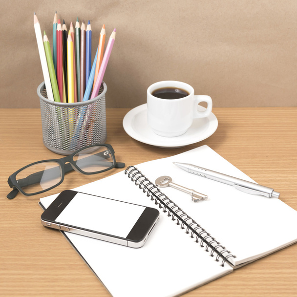 scrivania: caffè e telefono con chiave, occhiali, blocco appunti, penne
 - Foto, immagini