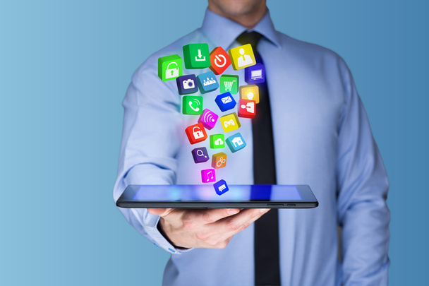 Επιχειρηματίας κρατώντας ένα tablet pc με κινητές εφαρμογές εικονίδια στην εικονική οθόνη. Διαδίκτυο και επιχειρηματική ιδέα. - Φωτογραφία, εικόνα