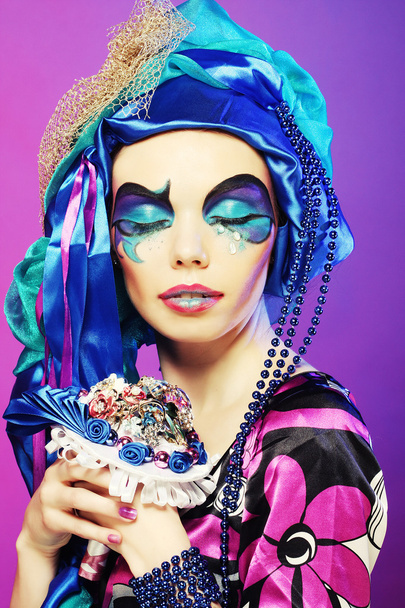 woman with creative make up holding a bouquet of jewelry - Foto, Bild
