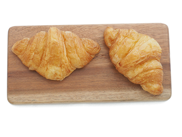 frisches Croissants Brot auf Holzteller isoliert auf weißem Hintergrund - Foto, Bild