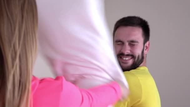 Young couple in bright pajamas, pillow fight, slowmotion - Imágenes, Vídeo