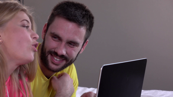 Cute man showing something on the laptop screen to his girl, slowmotion - Footage, Video