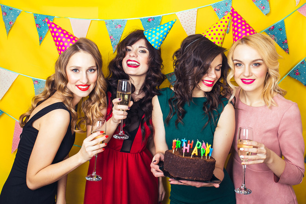 Portrait of joyful friends toasting and looking at camera at birthday party. Attractive friends celebrating a birthday. Smiling girls with glasses of champagne - Foto, Imagen