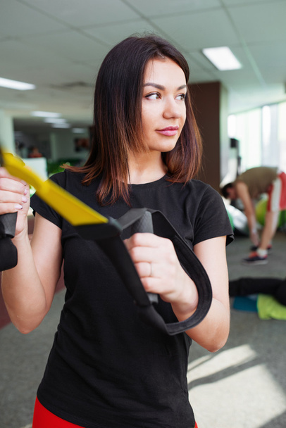Young beautiful woman training in gym using trx fitness straps - Fotoğraf, Görsel