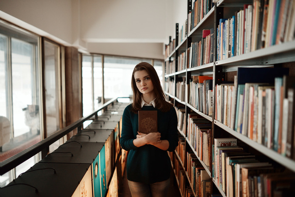 Beautiful girl in the library, smart. Fourteen years old. Education, school, college, exams. Preparation for school. - Фото, изображение