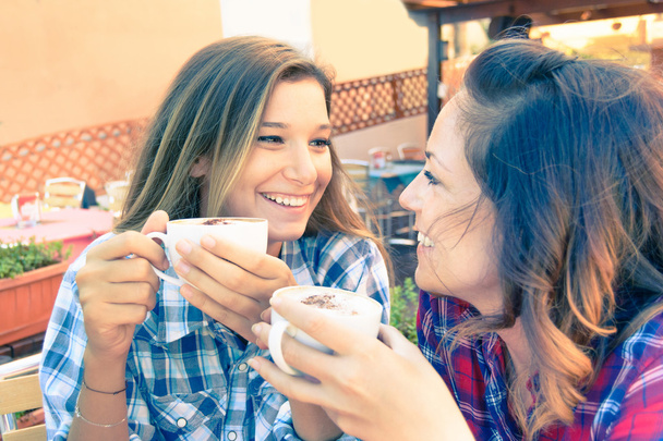 junge Hipster beste Freunde unterhalten sich beim Frühstück in der Bar über Klatsch und Tratsch - Konzept des Alltags Momente Leben und neue Technologie während einer Pause im Restaurant und trinken italienischen Cappuccino - Foto, Bild