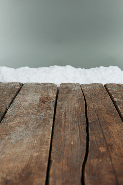 alte Holzbohlen mit Schnee auf grauem Hintergrund - Foto, Bild