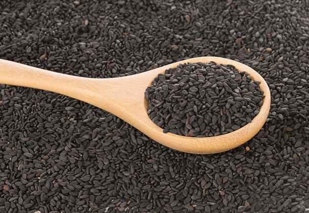 Semillas de sésamo negro en fondo de cuchara de madera
 - Foto, imagen