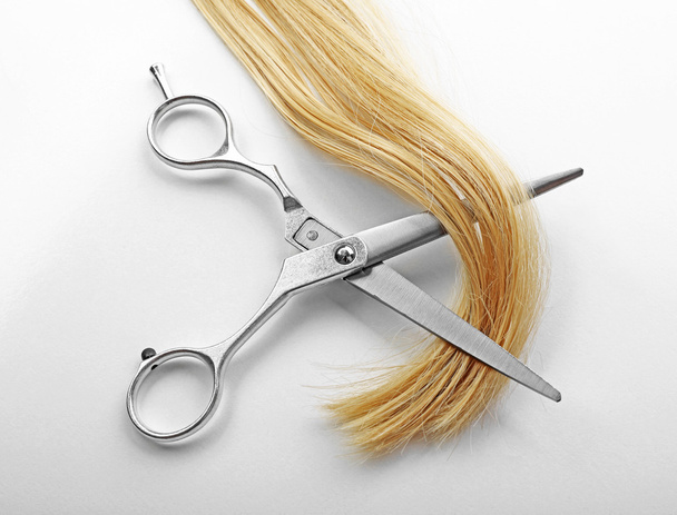 Hairdresser's scissors with strand of blonde hair - Fotografie, Obrázek