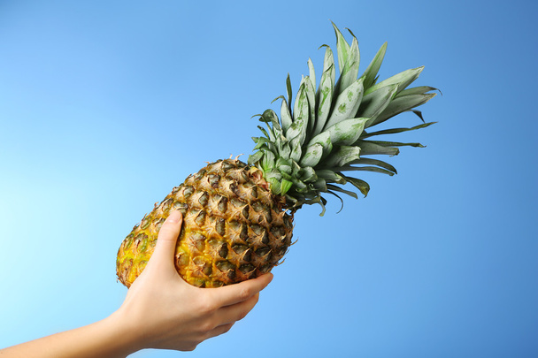 Female hand holding ripe pineapple - Фото, зображення