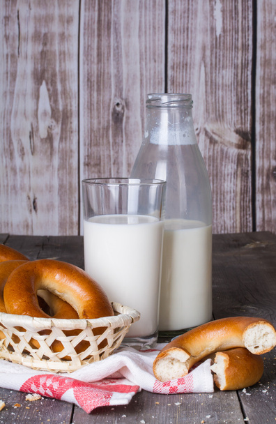 Milk and bagels on a wooden table - Фото, зображення