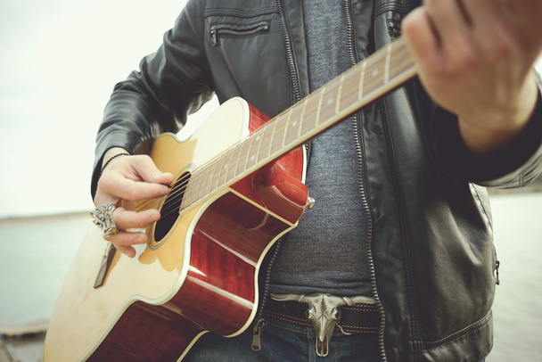 Vousatý muž hrát na kytaru venku poblíž retro auta - Fotografie, Obrázek