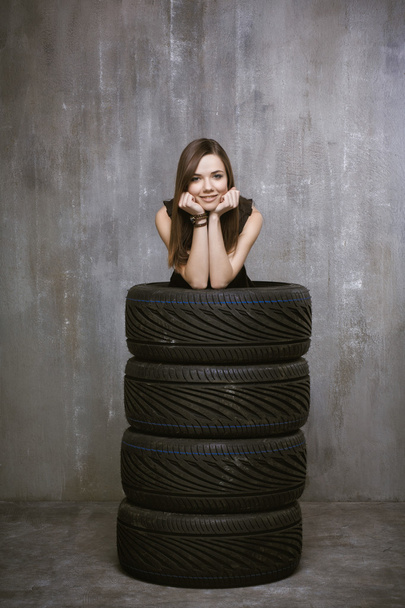 Portrait of a young girl who is inside automobile tires, on the  - 写真・画像