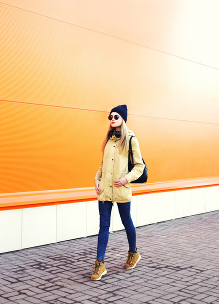 Fashion pretty woman walking in city over colorful orange backgr - Φωτογραφία, εικόνα