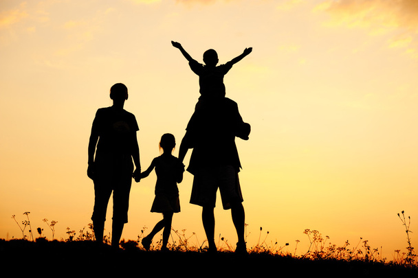 Boldog család nyári napnyugtakor réten - Fotó, kép