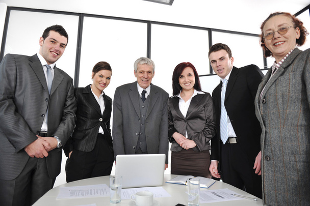 Группа компаний, стоящая в офисе и улыбающаяся
 - Фото, изображение
